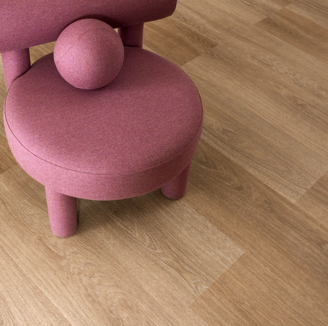 Raumansicht des Loose Lay Vinylbodens namens Natural Giant Oak beispielhaft mit einem Designer Sessel